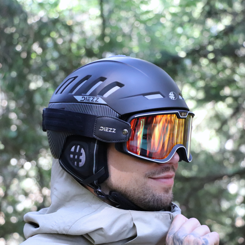 Homme portant un casque et un masque de ski photochromique DIEZZ noir avec écran orange réfléchissant, idéal pour le freeride.